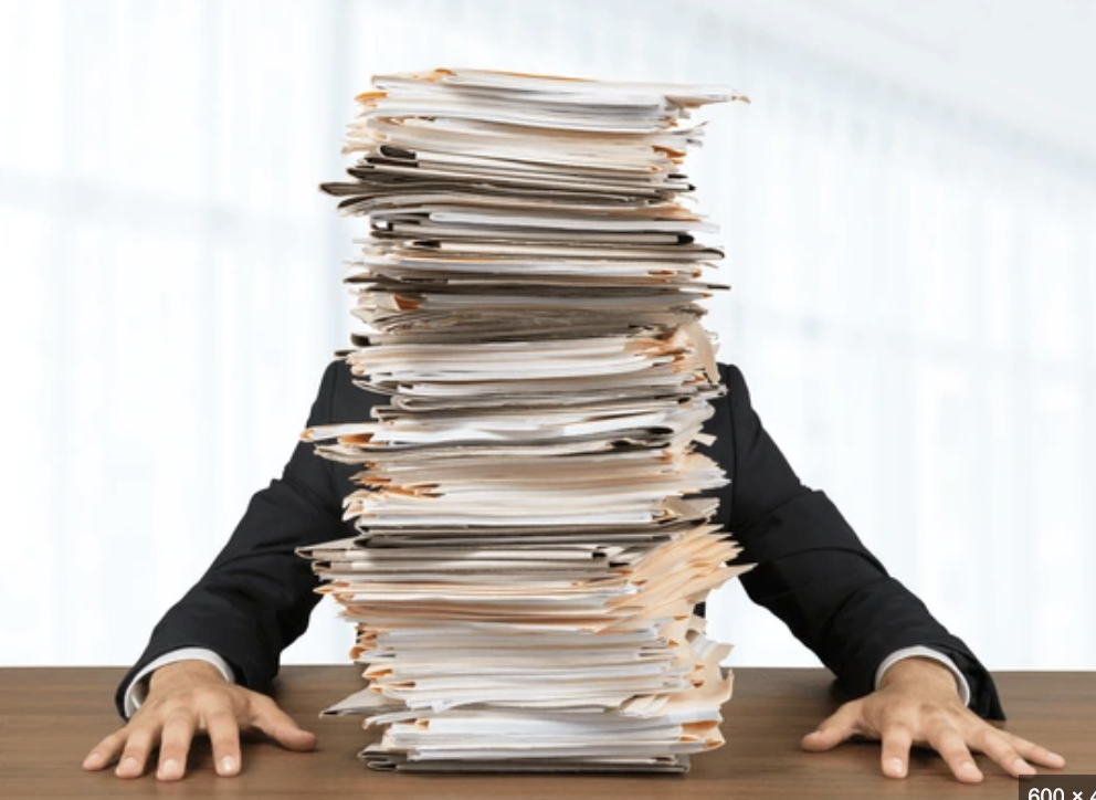 Stacks of paperwork representing manual processes